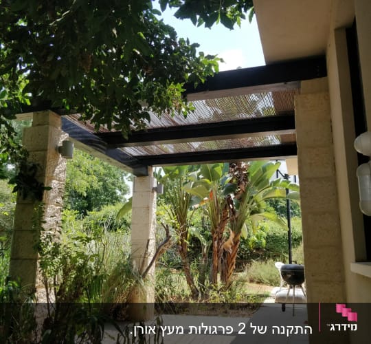 פרגולה מעץ עם צמחייה מסביב וגינה ירוקה